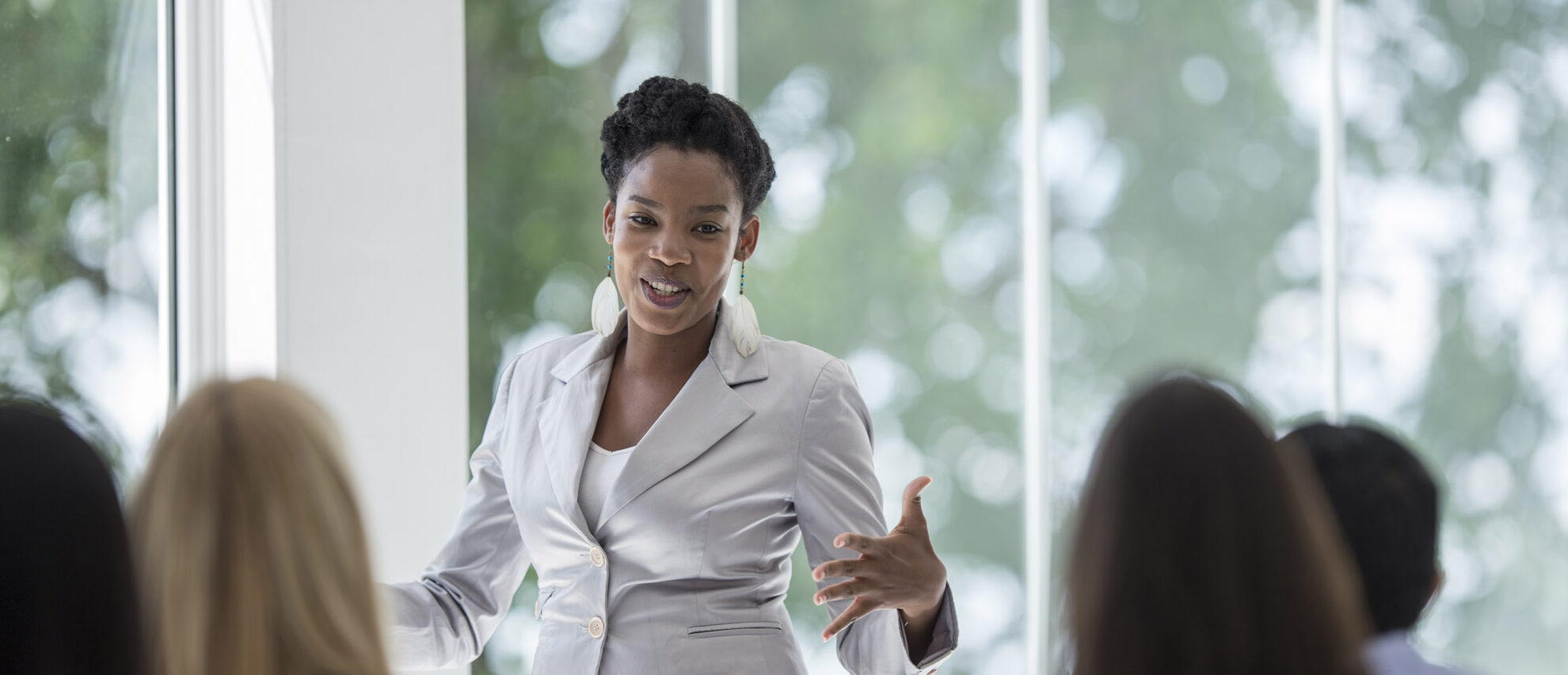 A young Black woman speaking to an audience